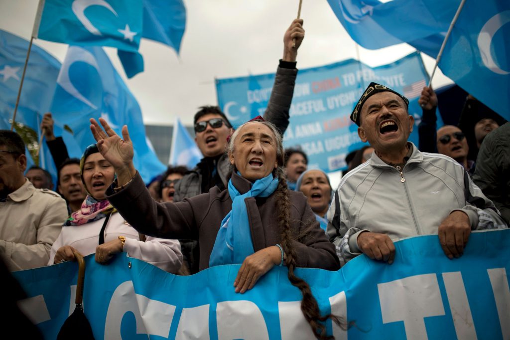 Rebiya Kadeer, center, former head of the pro-independence World Uyghur Congress, shouts slogans with others holding Uyghur flags, or pro-independence of Eastern Turkistan, during a protest in Brussels, Monday, Oct. 1, 2018.
