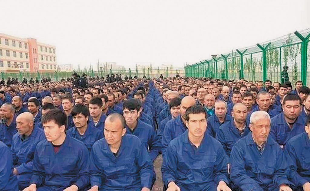 Uighur detainees listening to a “deradicalization” presentation at a reeducation camp, in a photo posted to the Xinjiang Judicial Administration’s WeChat account, Hotan Prefecture, Xinjiang, 2017

